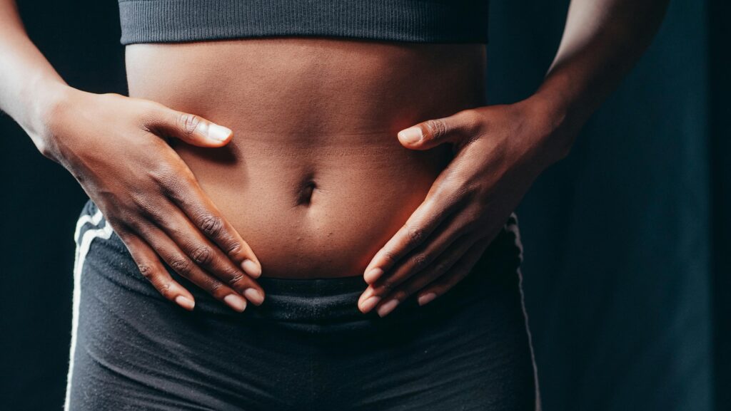 Person hält die Hände schützend auf den Bauch