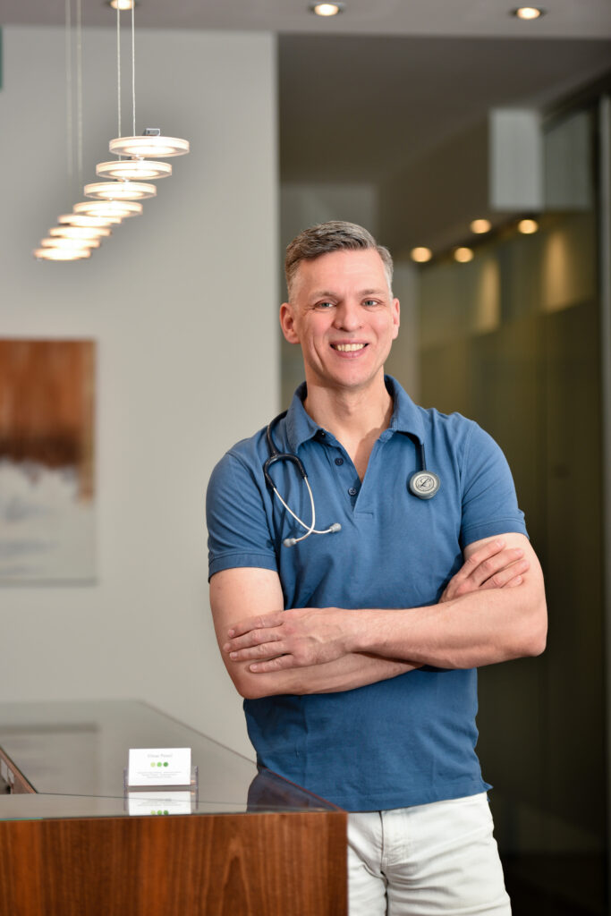 Elmar Pestel, Facharzt für Innere Medizin, mit Stethoskop in seiner Praxis in München